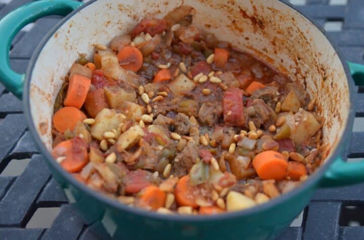 Garnish Middle eastern lamb stew with pine nuts