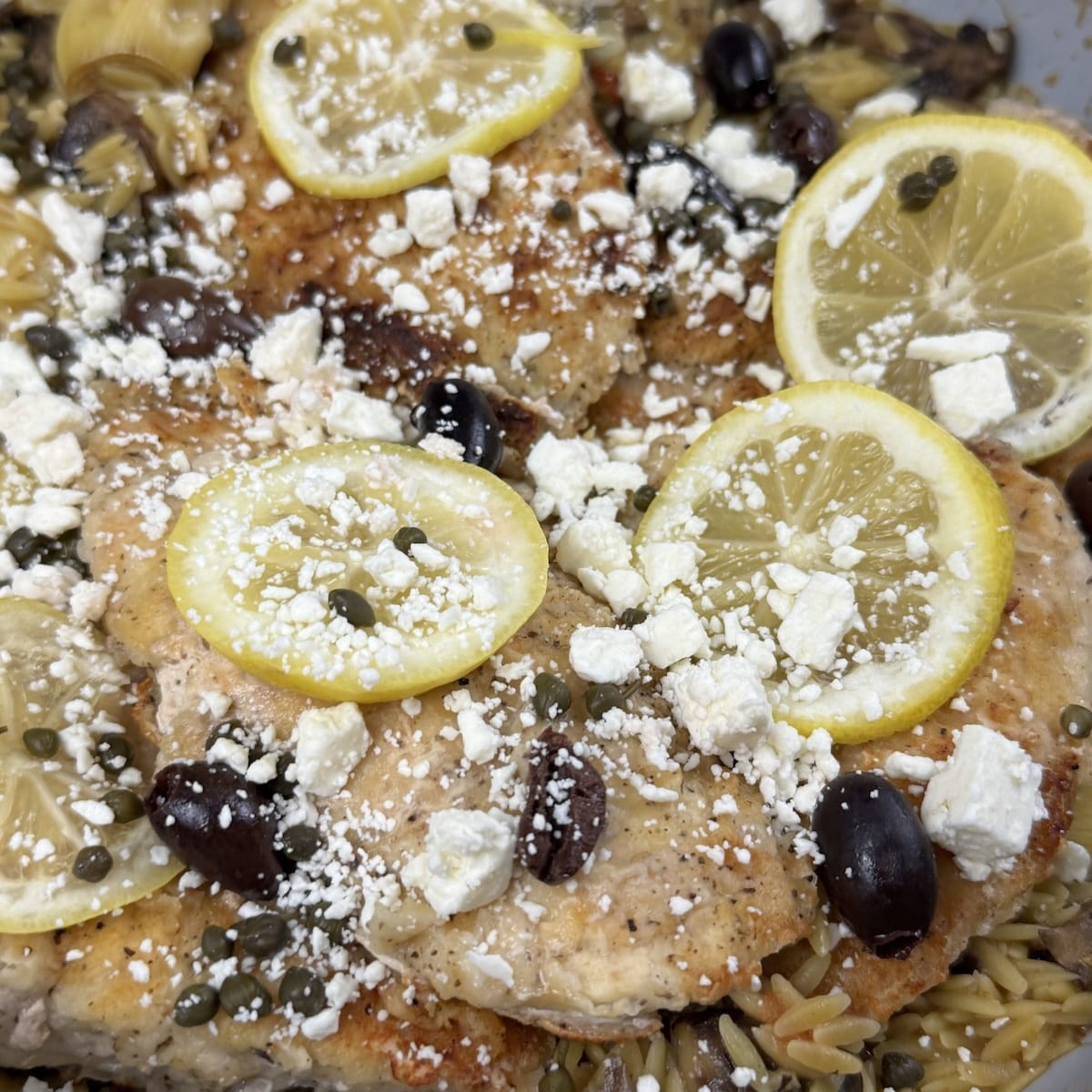 Mediterranean chicken with Orzo, sprinkled with feta, topped with kalamata olives and lemon slices.