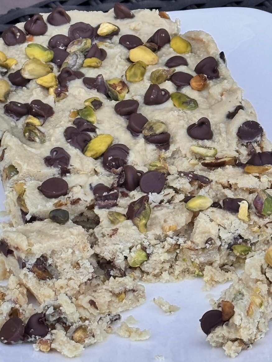 Pistachio halva with chocolate chips on a white plate.