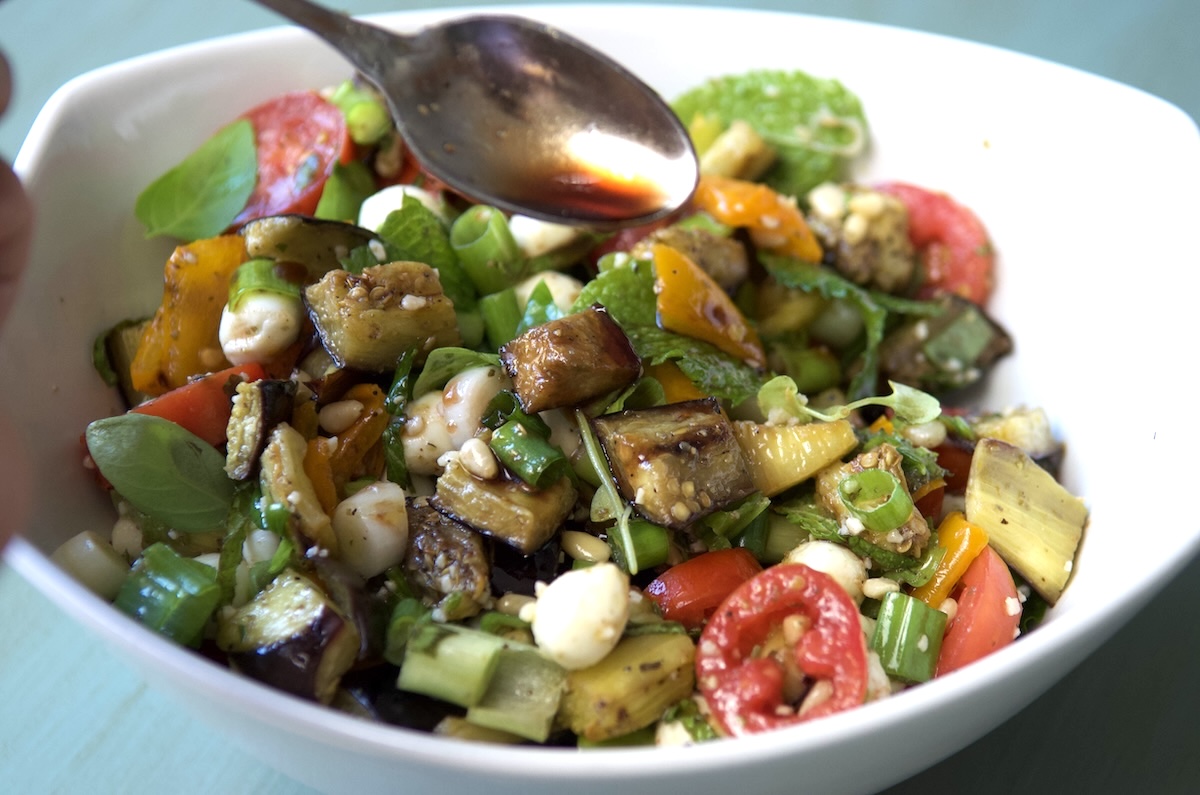 Drizzling pomegranate molasses on roasted eggplant salad