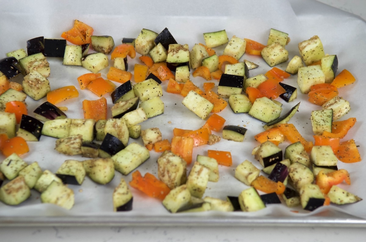 Diced eggplant and pepper on parchment paper and ready to roast.